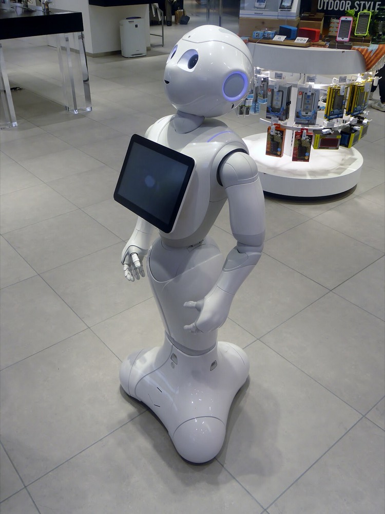 ソフトバンクの人型コミュニケーションロボット Pepper が胸のタブレットを付けて立つ姿